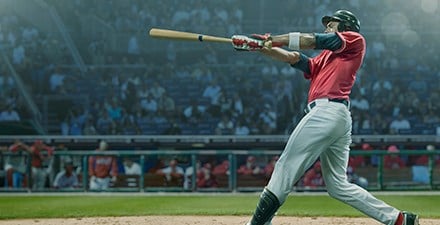 Pro baseball player swinging bat from home plate