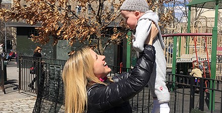 Emma Fitzsimmons holding her son up in the air.