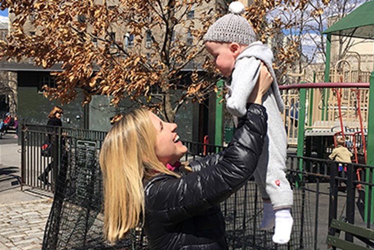 Emma Fitzsimmons holding her son up in the air.