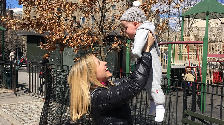 Emma Fitzsimmons holding her son up in the air.