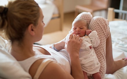 A woman holding her newborn baby.