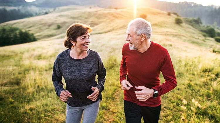 An adult couple enjoying the benefits of exercise outdoors.