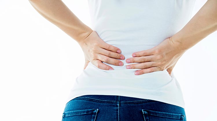 A woman with her hands on her lower back