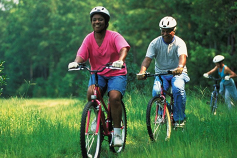 Three people biking outdoors.