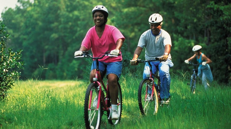 Three people biking outdoors.