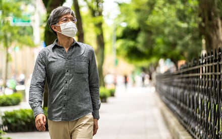 Masked man walking down the street.