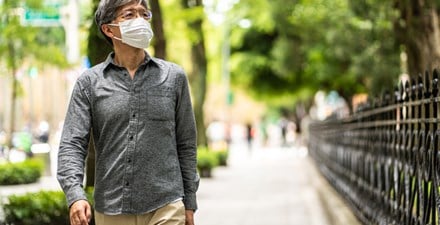 Masked man walking down the street.