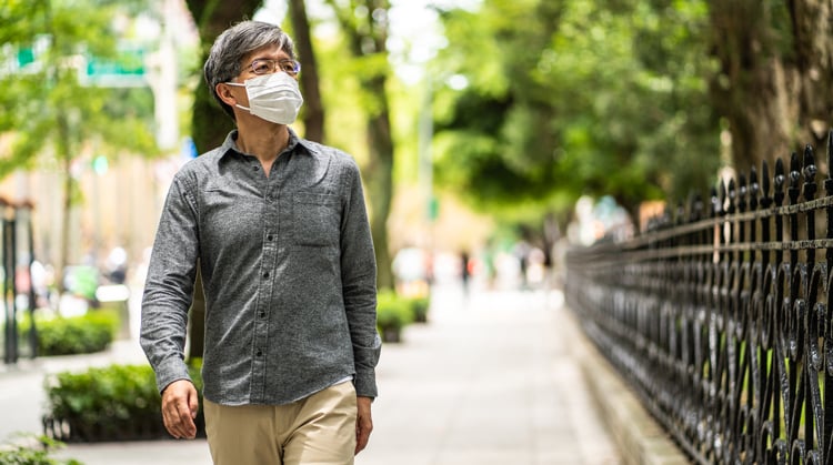 Masked man walking down the street.