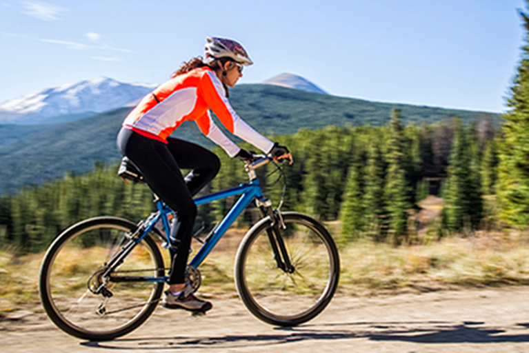 Woman cycling outside.
