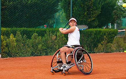 Person in a wheelchair playing tennis