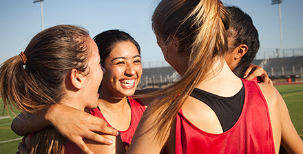 Female athletes in a huddle.