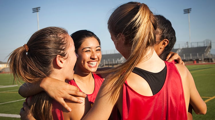 Female athletes in a huddle.