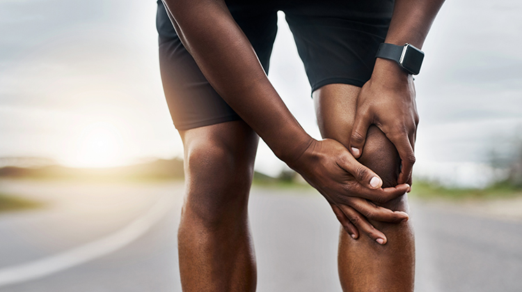 Man holding knee in pain.