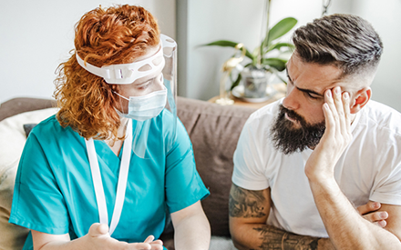 Patient and PT wearing masks discussing an issue.