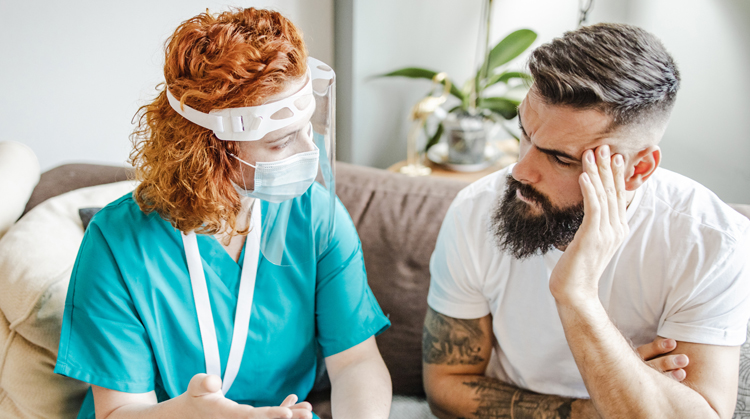 Patient and PT wearing masks discussing an issue.