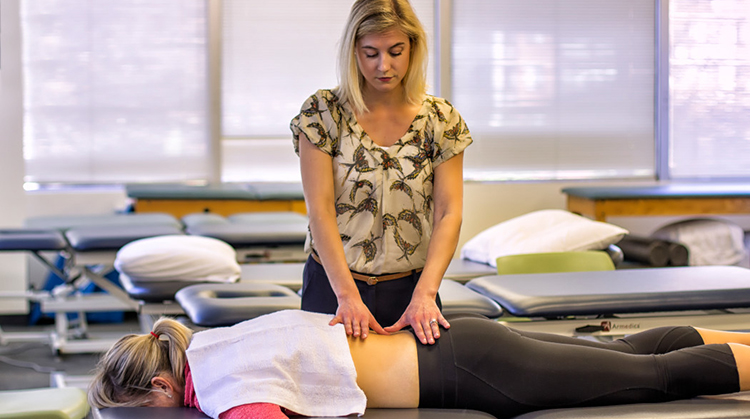 A physical therapist using hands-on therapy for back pain.