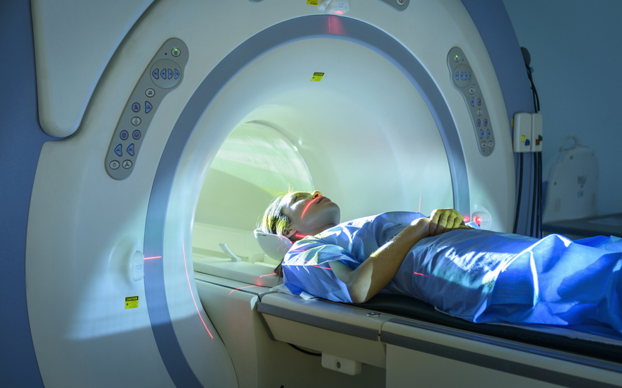 A person lying on a maching for an imaging scan.