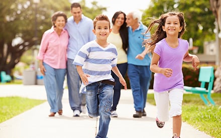 Family running together down the sidewalk.