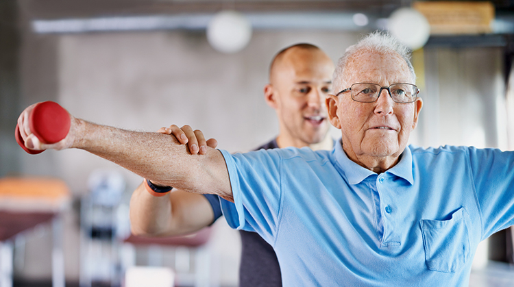 Physical Therapist assisting older adult with strength exercises for shoulders.