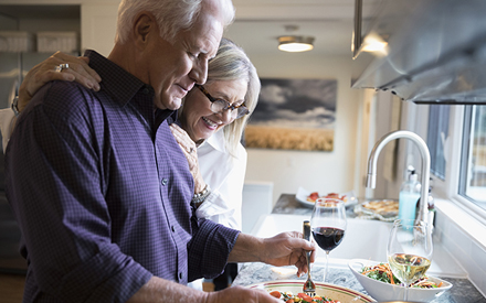 Older couple at kitchen counter.