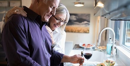 Older couple at kitchen counter.