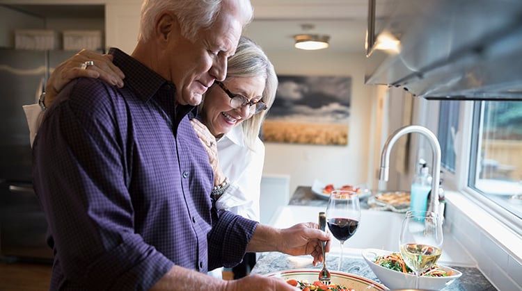 Older couple at kitchen counter.
