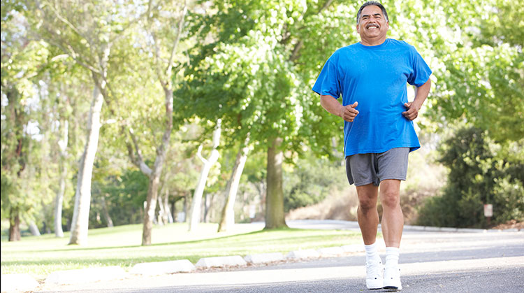 Man in blue shirt walking outdoors.