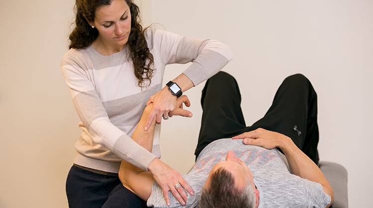 PT working on patient's shoulder.