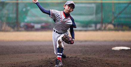 A young boy pitches a baseball