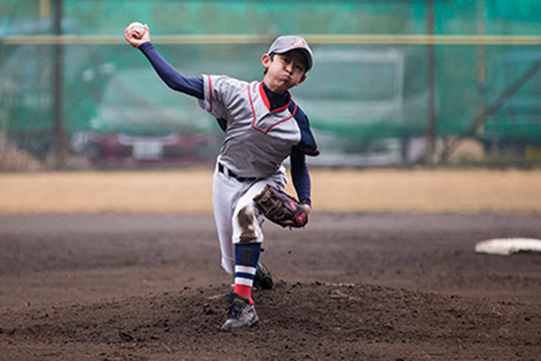 A young boy pitches a baseball