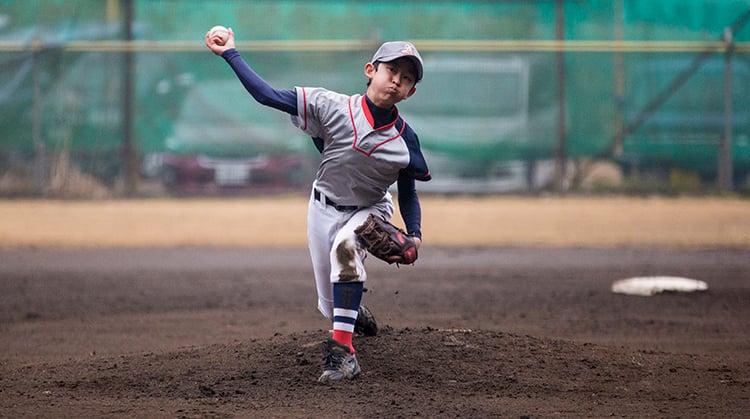 A young boy pitches a baseball
