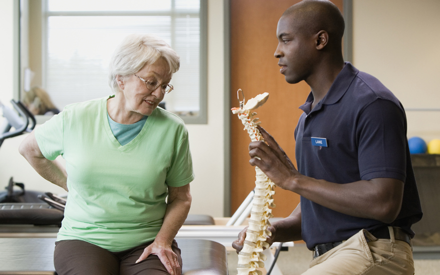 A physical therapist educates a patient about the spine.