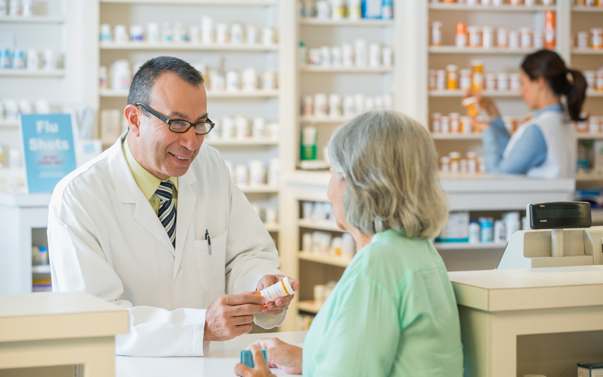 An older adult picking up a prescription at the pharmacy.