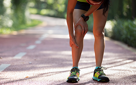 Runner on path holding shin