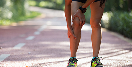 Runner on path holding shin