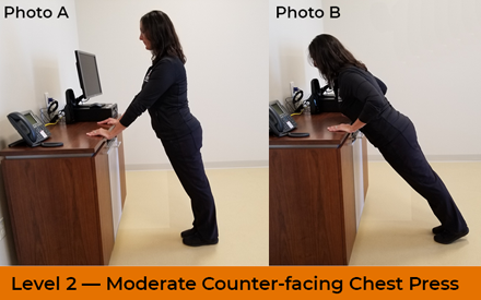 A physical therapist demonstrates a counter-facing chest press exercise