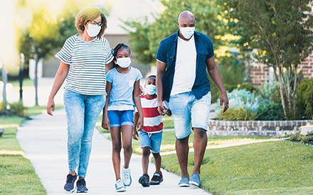 Family wearing masks and walking.