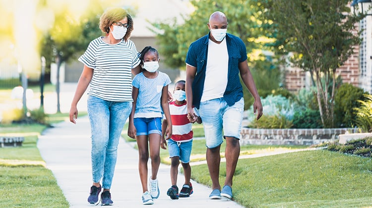 Family wearing masks and walking.