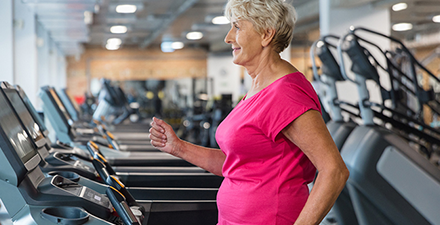 Older adult walking on treadmill.